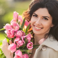 Smiling woman with braces holding flowers
